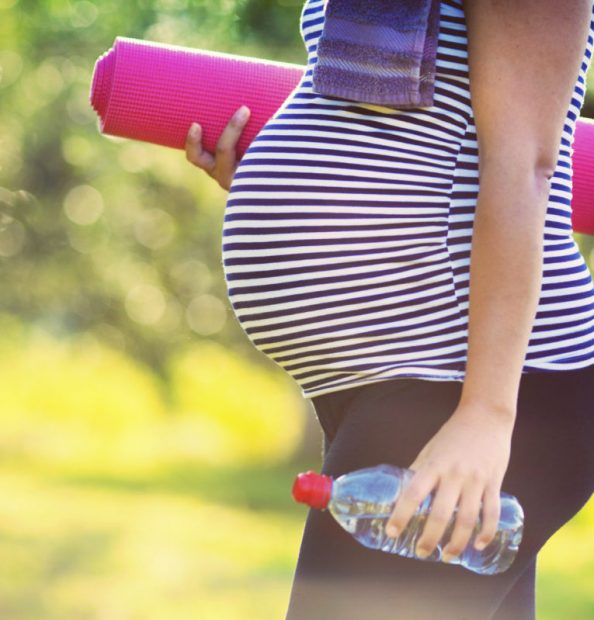 Pregnant woman with yoga mat